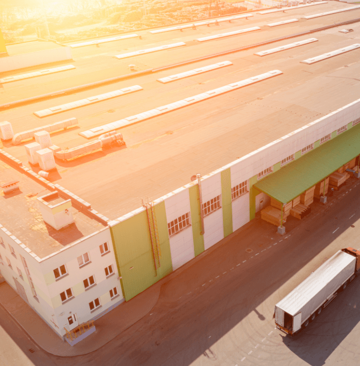 Aerial view of a large warehouse with delivery trucks outside.