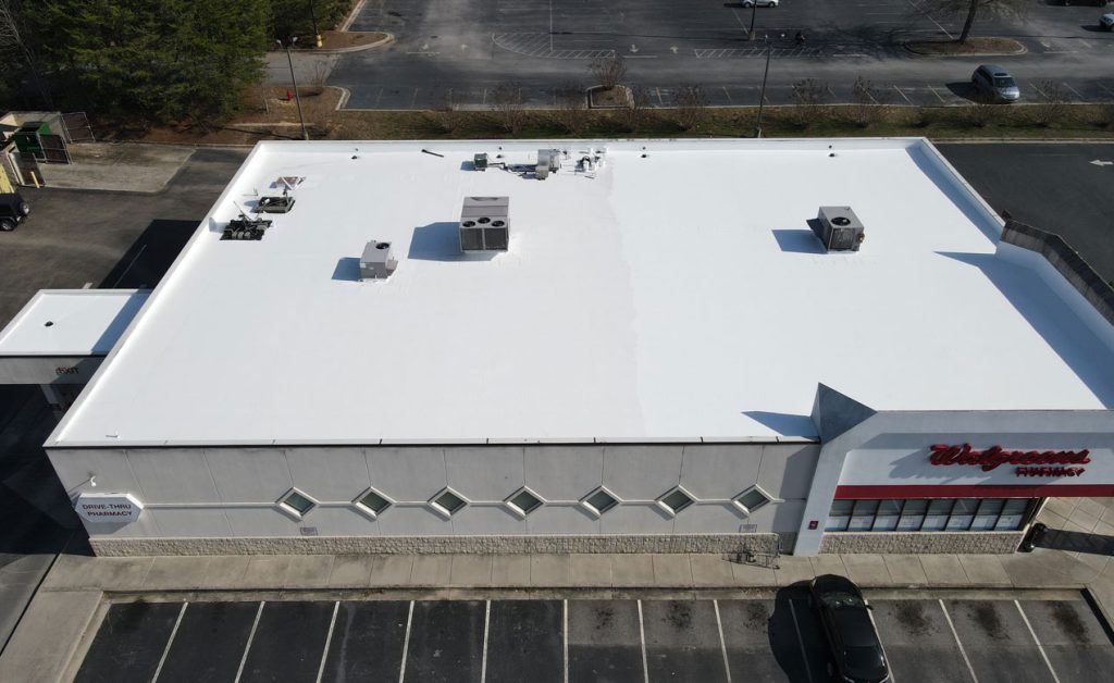 A large white flat roof with ventilation units on an industrial building.