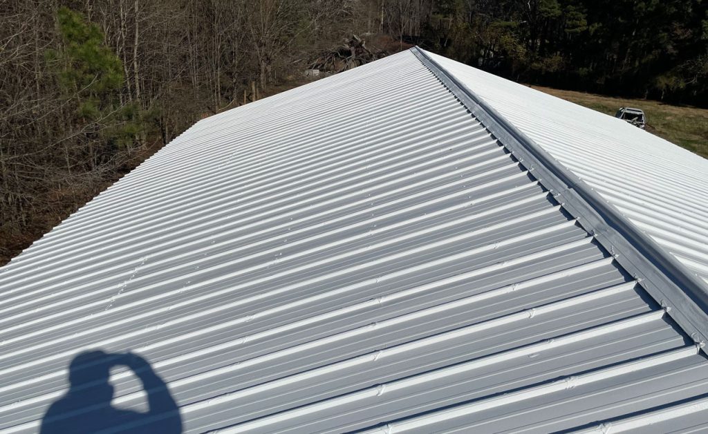 A long white corrugated metal roof under clear weather.