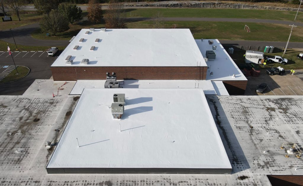 Aerial view of flat white roofs with HVAC units and vents.
