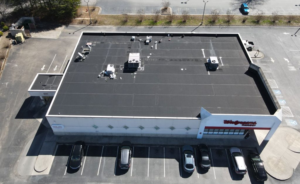 A flat rooftop with several ventilation units on a commercial building.