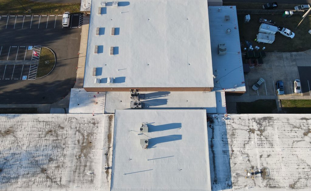 Aerial view of white rooftops with shadows on a sunny day.